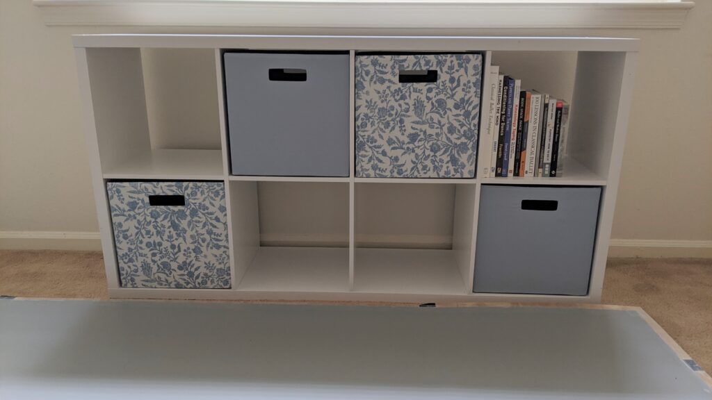 a white cube shelf unit with light blue and blue/white floral fabric drawers