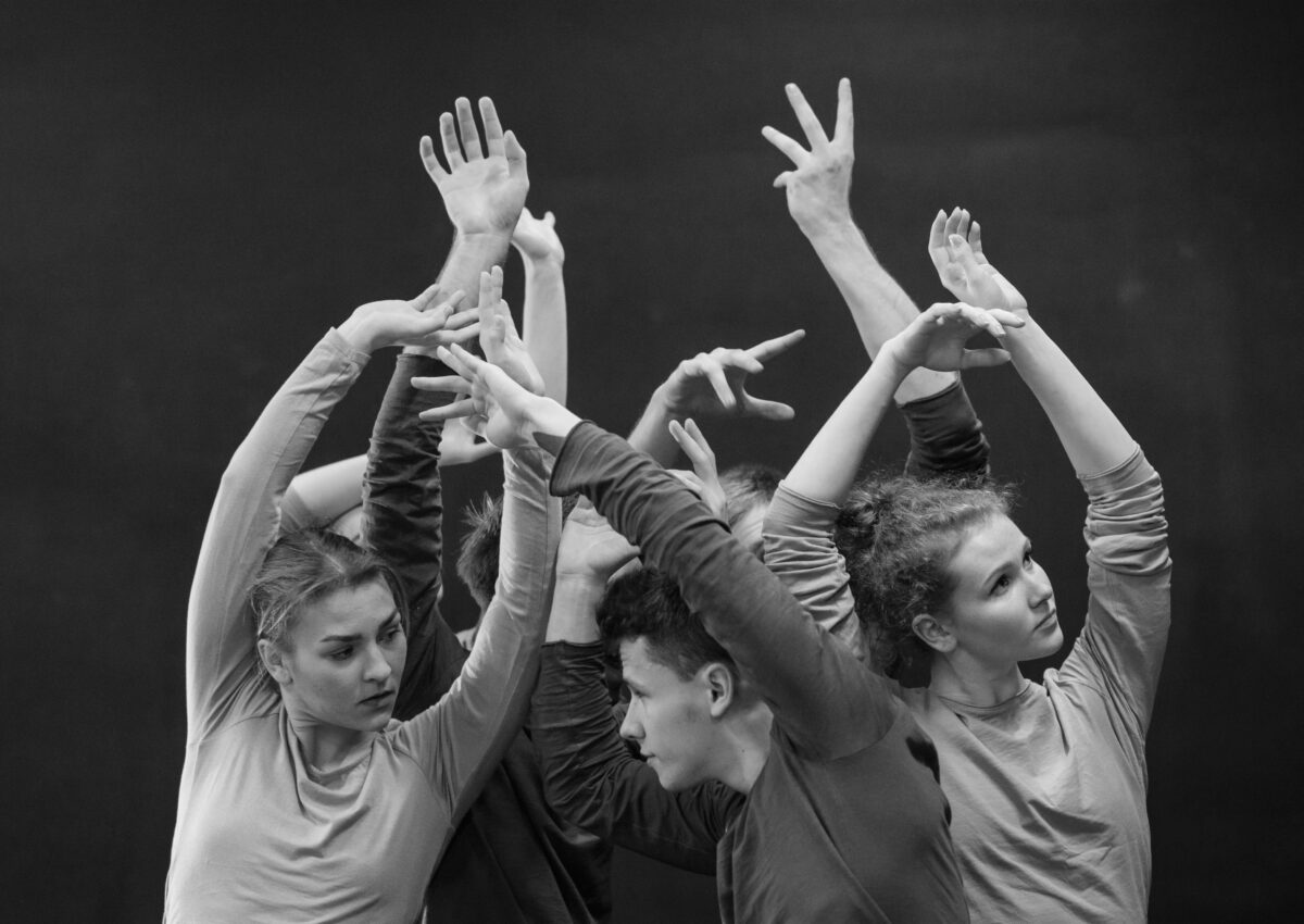 black and white photo of five adult dancers in a clump with their arms up | Dance Insight: keep taking class as a dance professional