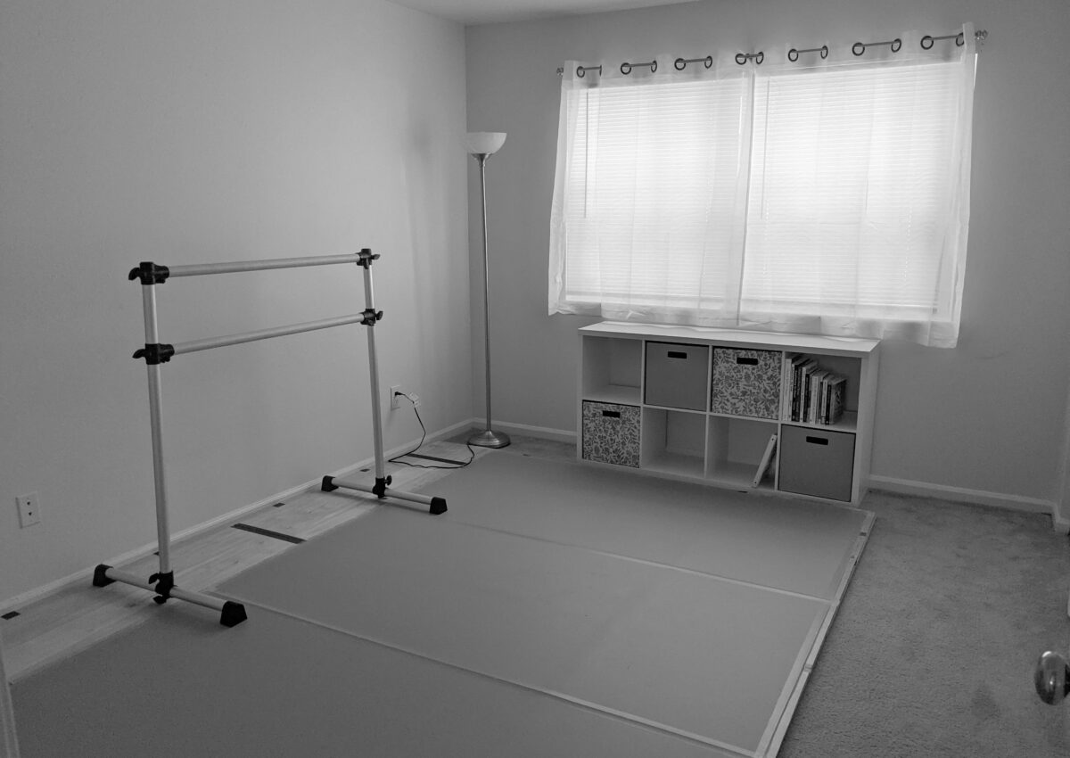 black and white photo of a home dance floor on carpet - includes ballet barre, marley floor, and cubby shelf | Dance Insight