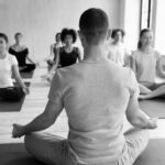 black and white photo of people seated cross-legged meditating | Side Hustle Ideas for Performing Artists | Dance Insight