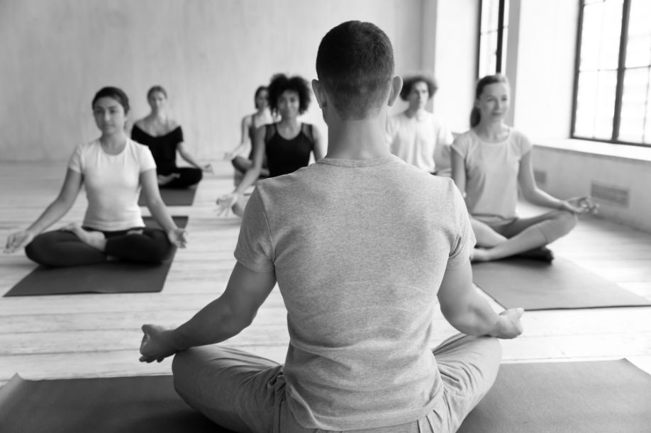 black and white photo of people seated cross-legged meditating | Side Hustle Ideas for Performing Artists | Dance Insight