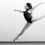 black and white photo of a woman in black leotard and pointe shoes leaping | How to Get Started as a Professional Dancer | Dance Insight