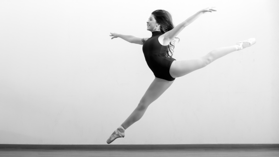 black and white photo of a woman in black leotard and pointe shoes leaping | How to Get Started as a Professional Dancer | Dance Insight